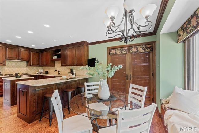 Dining area with light wood-style floors, a chandelier, recessed lighting, and ornamental molding | Image 14