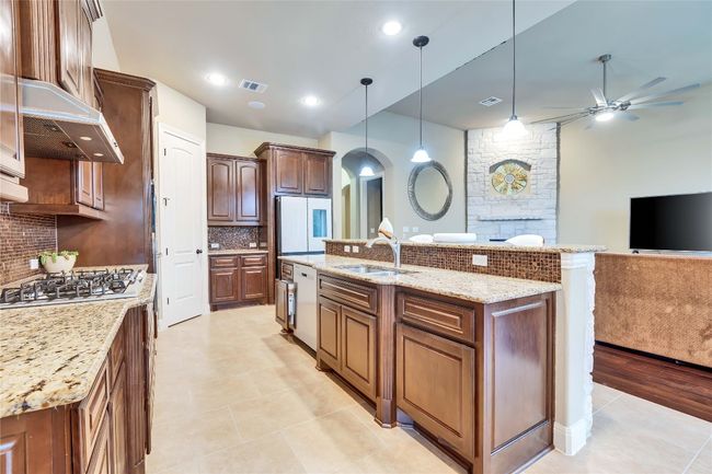 Gourmet kitchen with appliances, exhaust hood, cabinet and pantry space. | Image 23