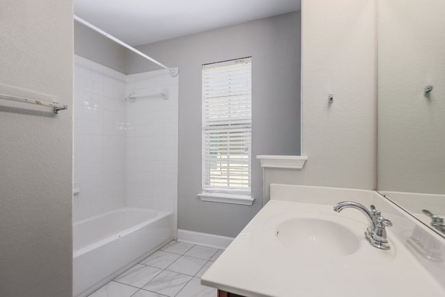 Bathroom featuring vanity, shower / tub combination and tile flooring | Image 15
