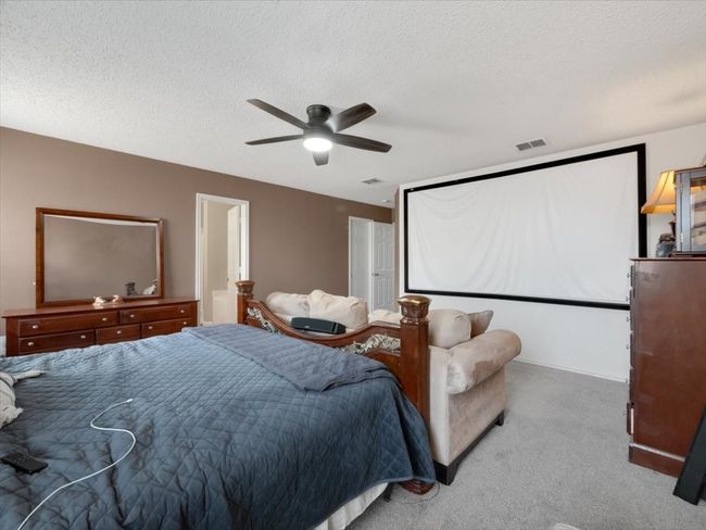 Carpeted bedroom featuring ceiling fan and a textured ceiling | Image 16