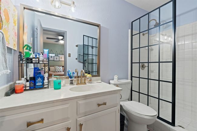 Bathroom featuring vanity, a ceiling fan, a stall shower, and toilet | Image 25