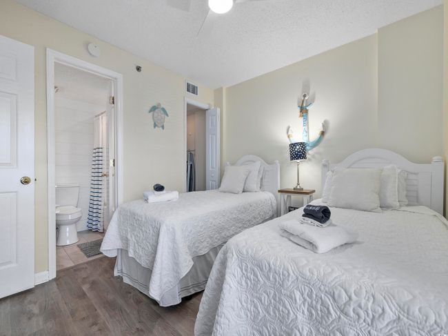 Bedroom with visible vents, ensuite bath, dark wood-style flooring, ceiling fan, and a textured ceiling | Image 19