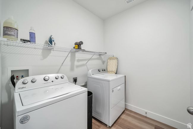 Laundry area featuring laundry area, visible vents, washing machine and dryer, light wood-type flooring, and baseboards | Image 14