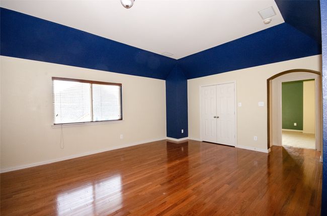 Empty room featuring arched walkways, wood finished floors, baseboards, and high vaulted ceiling | Image 15