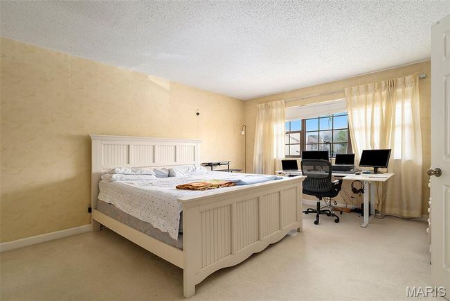 Bedroom featuring light carpet, a desk, and a textured ceiling | Image 13