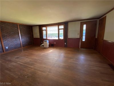 Foyer entrance with brick wall, crown molding, and dark hardwood / wood-style flooring | Image 2