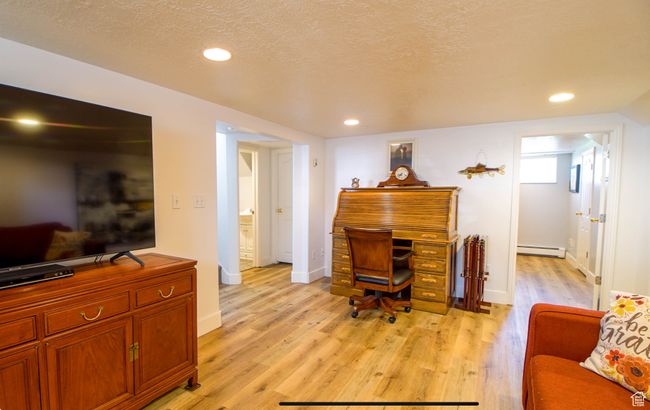 Office with baseboard heating, light wood-style floors, recessed lighting, baseboards, and a textured ceiling | Image 10