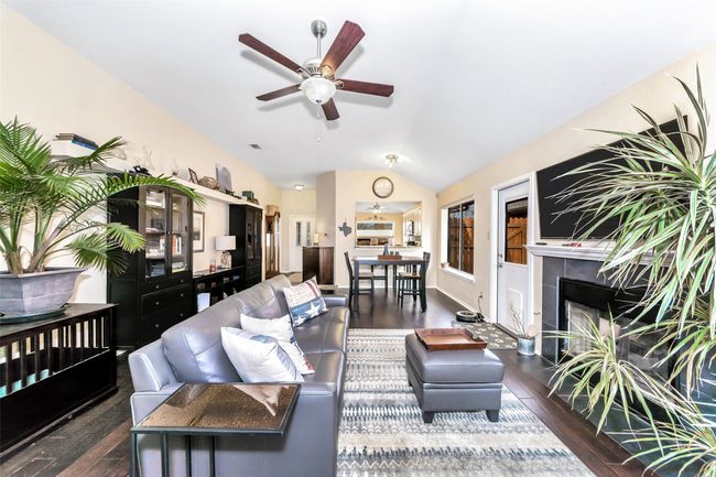 Living room with a fireplace, vaulted ceiling, hardwood / wood-style floors, and a ceiling fan | Image 13