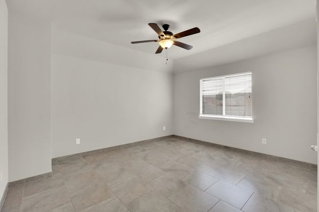 Spare room with a ceiling fan and baseboards | Image 24