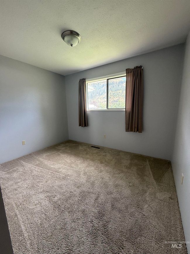 Carpeted empty room with a textured ceiling | Image 31