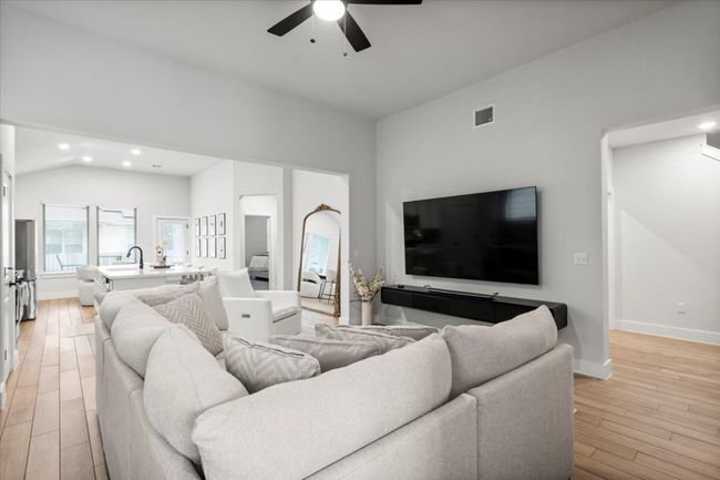 Living room featuring a ceiling fan, light wood finished floors, recessed lighting, and lofted ceiling | Image 10