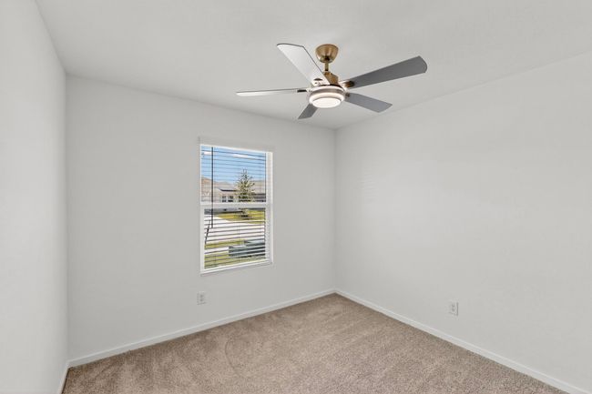 Empty room with carpet floors, baseboards, and a ceiling fan | Image 23
