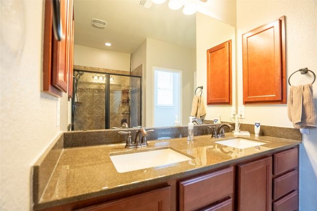 Full bathroom featuring a shower stall and double vanity | Image 15