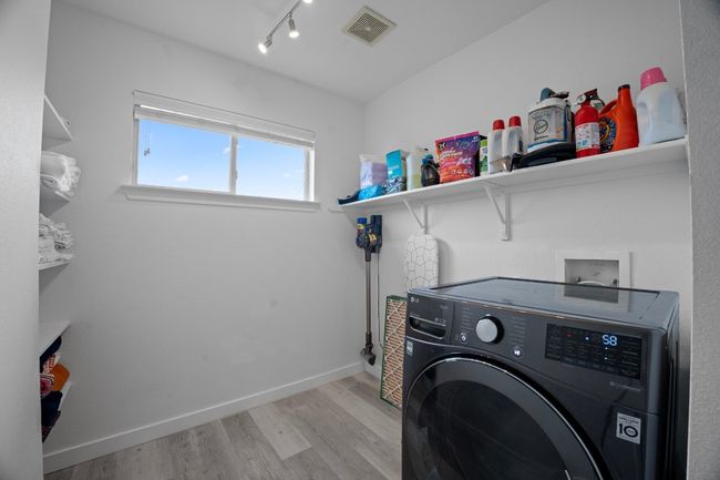 Laundry area featuring washer / dryer, light wood-style flooring, and track lighting | Image 28