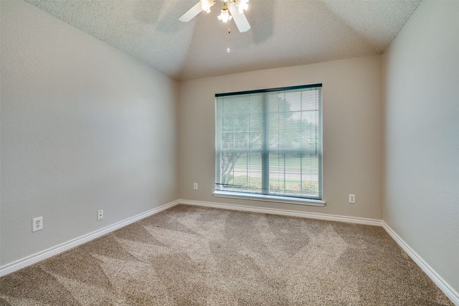 Spare room featuring carpet, a textured ceiling, a ceiling fan, and vaulted ceiling | Image 17