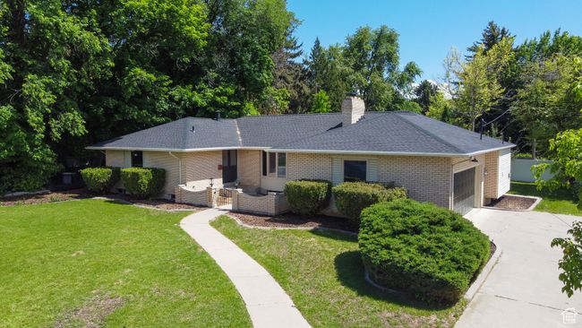 Single story home featuring brick siding, concrete driveway, a garage, roof with shingles, and a front lawn | Image 22
