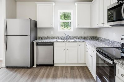 The kitchen features granite countertops and a full suite of stainless steel appliances. | Image 2