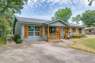 Ranch-style house featuring covered porch and a front lawn | Image 2