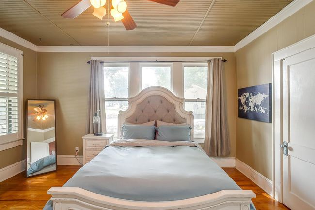 Bedroom with wood finished floors, crown molding, and a ceiling fan | Image 40