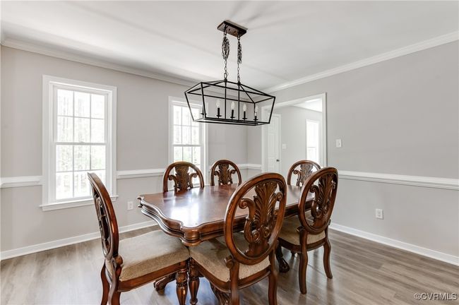 Dining room featuring a chandelier, wood finished floors, crown molding, and baseboards | Image 11