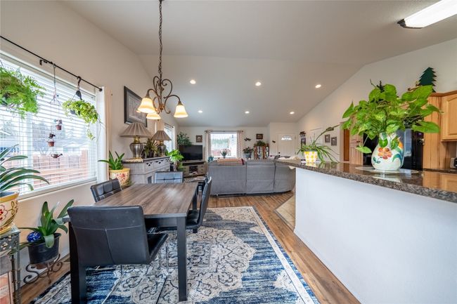 Dining room featuring lofted ceiling, recessed lighting, light wood finished floors, and a chandelier | Image 7