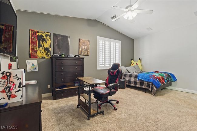 Carpeted bedroom featuring ceiling fan, lofted ceiling, visible vents, and baseboards | Image 28