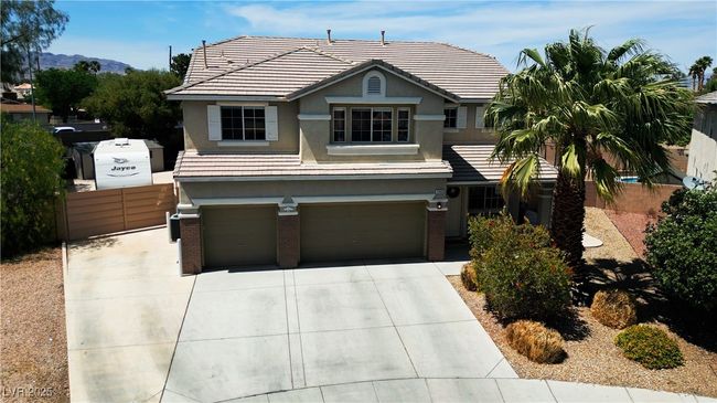 View of front facade featuring driveway, stucco siding, brick siding, and a garage | Image 54