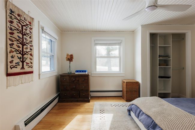 Bedroom with wood ceiling, ornamental molding, light hardwood / wood-style flooring, and a baseboard heating unit | Image 14