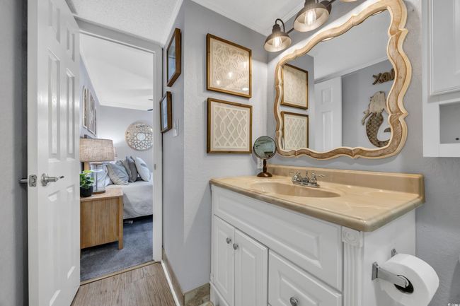 Bathroom with vanity, wood finished floors, ensuite bath, and crown molding | Image 8