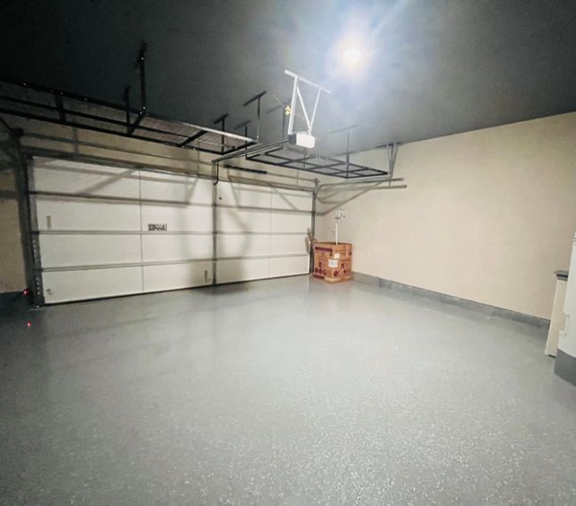 Garage with a garage door opener and baseboards | Image 11