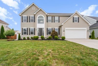 View of front of home with a front yard and a garage | Image 1