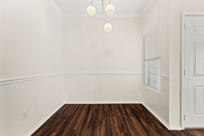 Spare room with dark wood-style floors, crown molding, and baseboards | Image 15