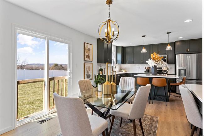 Dining room featuring light wood-type flooring and a chandelier | Image 11