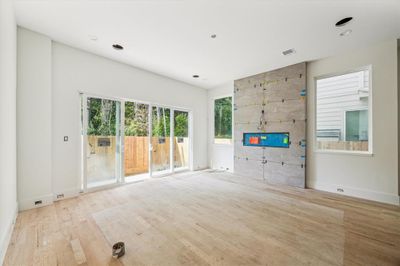 Alternate view of living, note hardwoods throughout, statement fireplace and sliders that open to backyard and foliage views. | Image 3