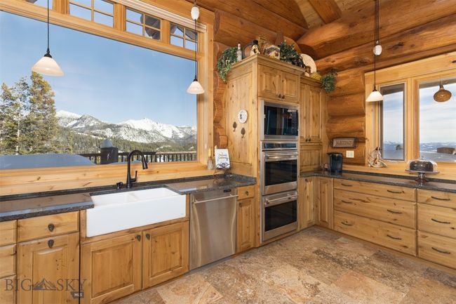 Main level kitchen with double farmhouse sink, stainless steel appliances, including double wall ovens, hidden small appliance storage and deep drawer storage capacity. | Image 32