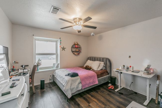 Unit 4900 Third Bedroom with ceiling fan, dark wood-type flooring, and a textured ceiling | Image 20