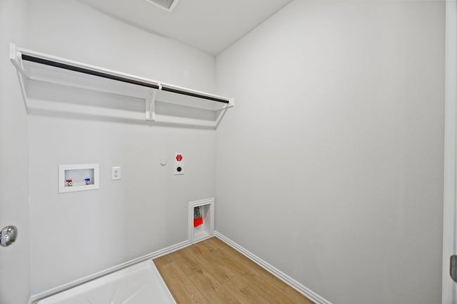 Laundry area featuring hookup for an electric dryer, hookup for a gas dryer, light wood finished floors, and washer hookup | Image 13