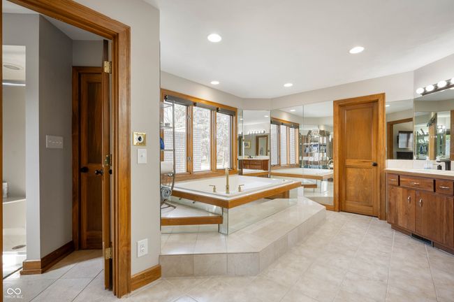 bathroom with tile patterned flooring, baseboards, a garden tub, recessed lighting, and vanity | Image 24