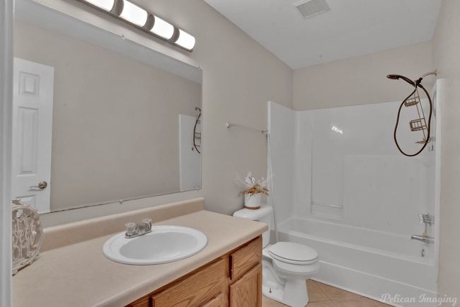 Full bathroom featuring toilet, shower / bathing tub combination, vanity, and tile patterned floors | Image 14