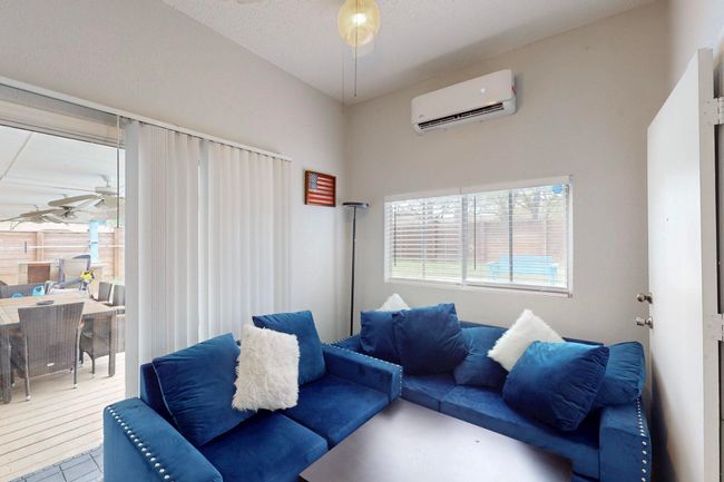 Living area featuring a ceiling fan and a wall mounted AC | Image 27