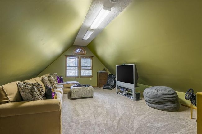 Carpeted living area with lofted ceiling | Image 56