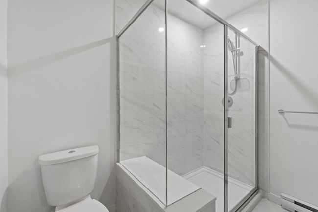 Full bath with a baseboard heating unit and a marble finish shower | Image 22