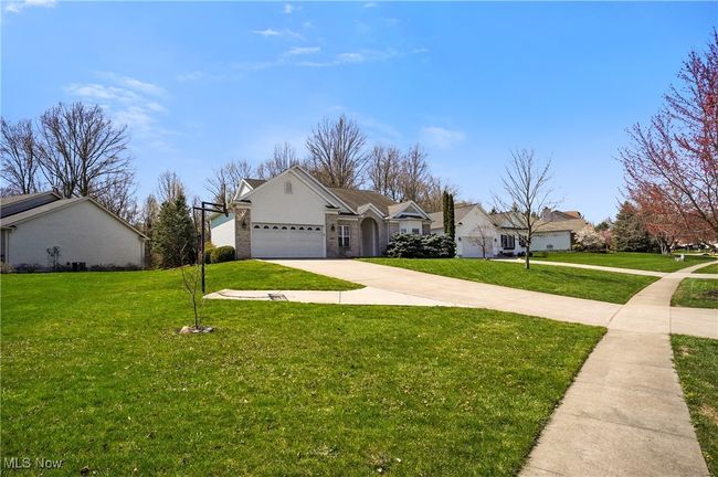 View of front of house featuring concrete driveway, a front lawn, and an attached garage | Image 5