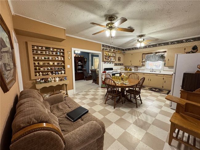 Dining room with light flooring, a ceiling fan, ornamental molding, and a textured ceiling | Image 14