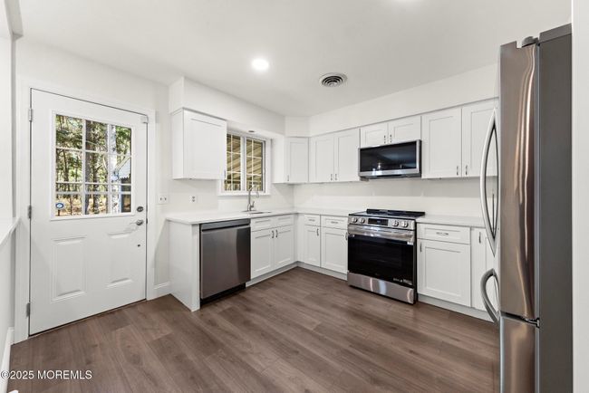 Chef's kitchen with stainless appliances and quartz countertops | Image 10