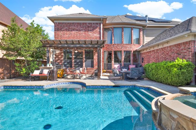 The covered patio features a stone kitchen area with built-in grill. It would be very easy to expand this area to create your dream outdoor kitchen and living area. | Image 24