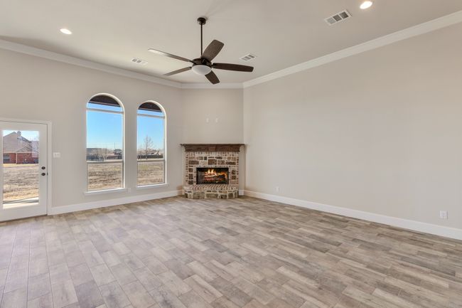 Unfurnished living room featuring a ceiling fan, wood finished floors, crown molding, recessed lighting, and baseboards | Image 4