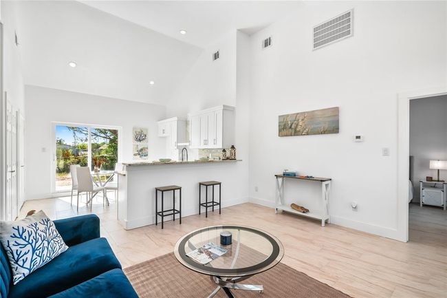 Bright and inviting living room featuring high ceilings, abundant natural light, and seamless flow to the kitchen, perfect for entertaining and relaxation. | Image 7