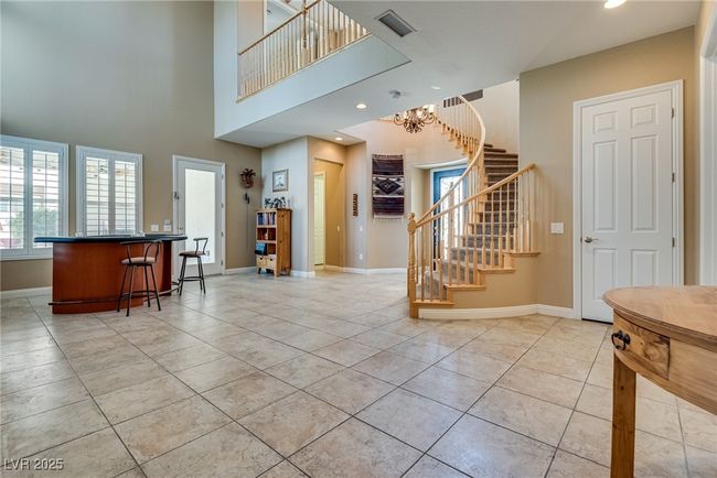 Foyer entrance featuring stairway, recessed lighting, baseboards, a chandelier, and light tile patterned flooring | Image 14
