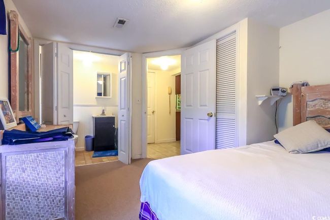 Bedroom with light colored carpet, light tile patterned floors, and connected bathroom | Image 10